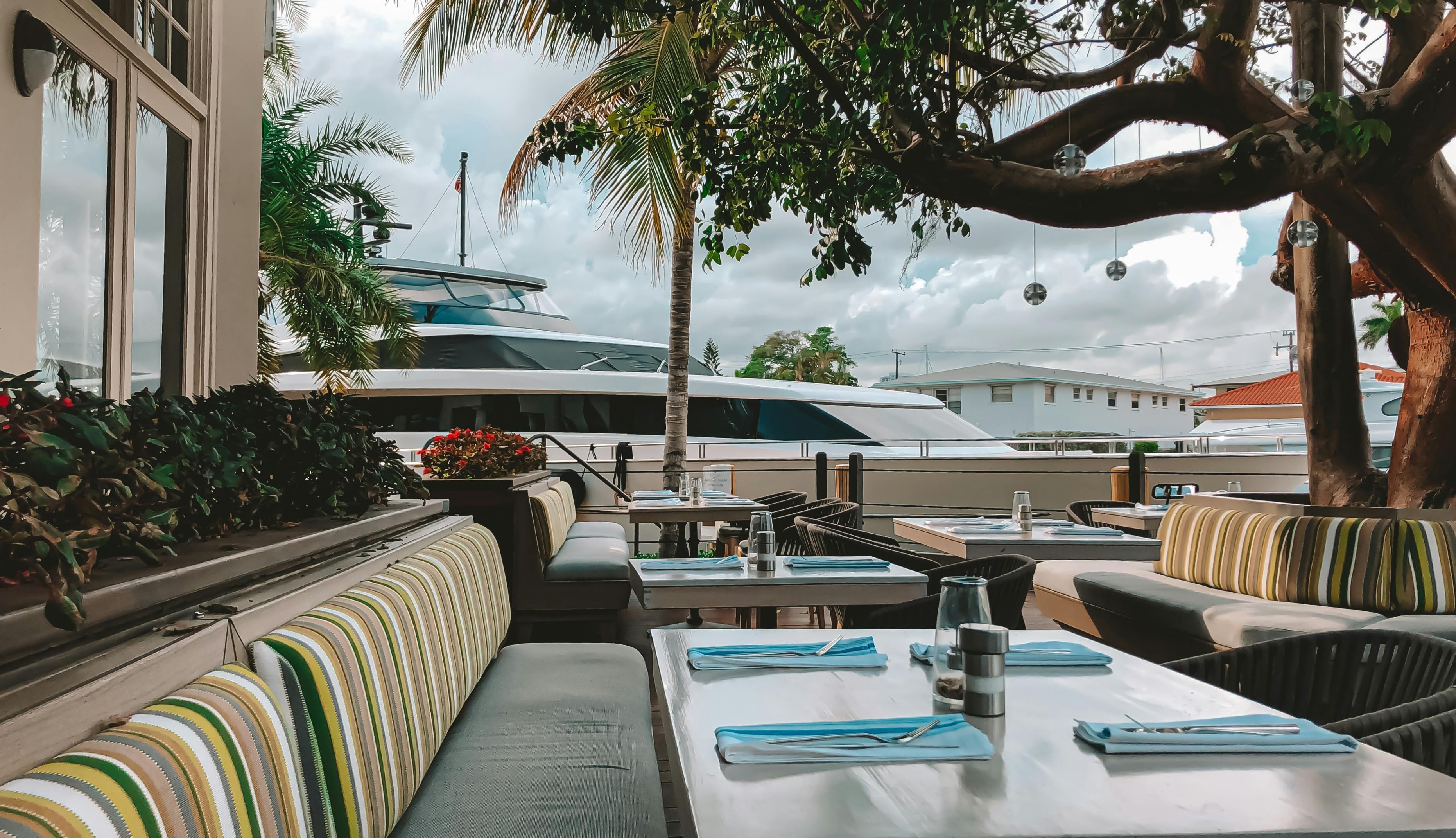 Outdoor waterfront terrace with tables set for brunch